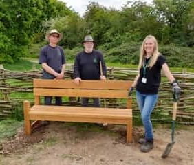 3 volunteers looking proud of a newly installed bench